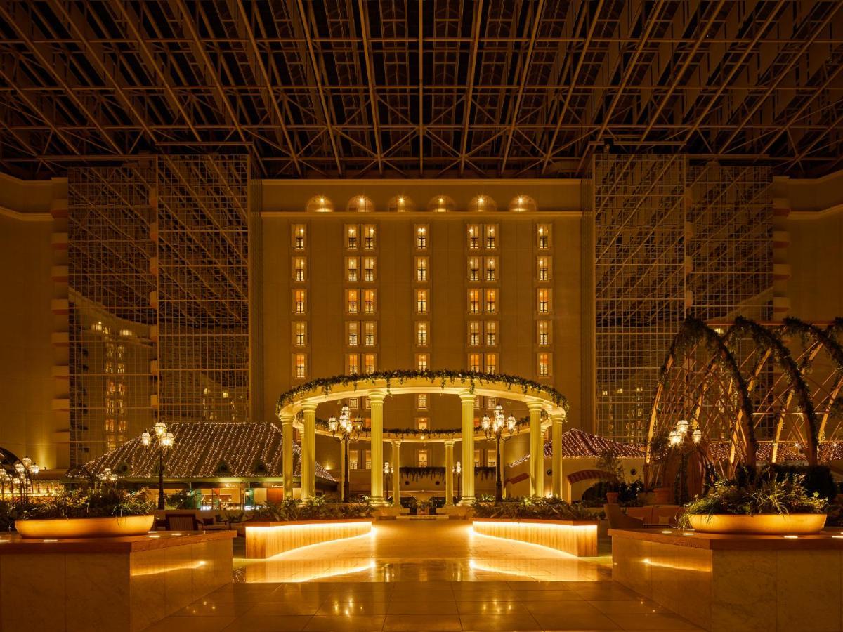Grand Nikko Tokyo Bay Maihama Hotel Urajaszu Kültér fotó The photo shows the interior of a luxurious hotel or resort. It features a spacious atrium with elegant architecture, including a high ceiling supported by beams. The area is well-lit with warm, ambient lighting that highlights various design element