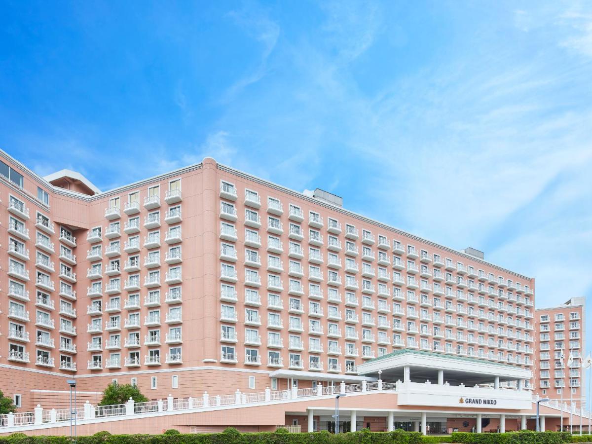 Grand Nikko Tokyo Bay Maihama Hotel Urajaszu Kültér fotó The photo depicts a large hotel building featuring a contemporary architectural design. The structure is predominantly pink, with multiple floors and numerous windows. There is a covered entrance at the front, and the setting appears to be well-maint