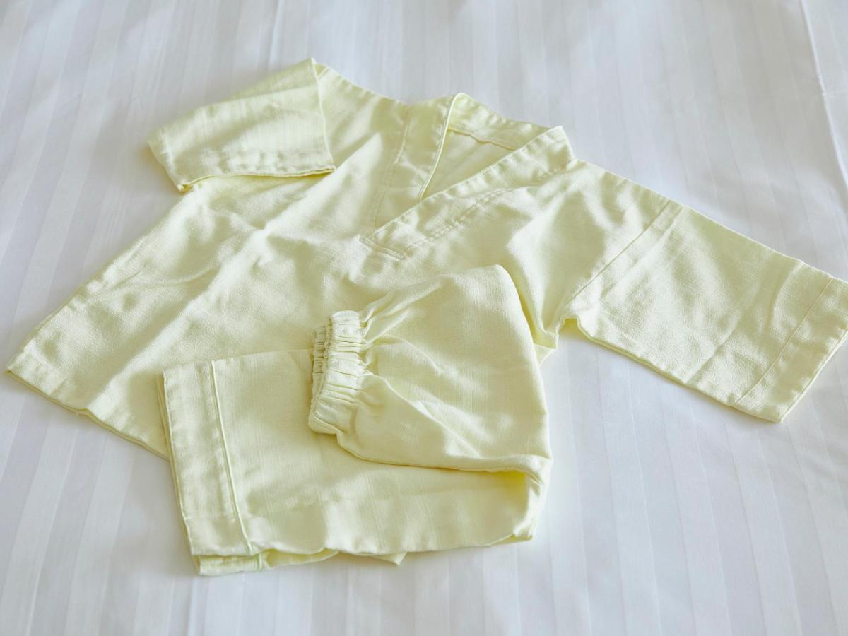 Grand Nikko Tokyo Bay Maihama Hotel Urajaszu Kültér fotó The photo shows a small, traditional outfit made of light yellow fabric. The outfit includes a short-sleeved top with a V-neck and a pair of matching pants. The design is simple, featuring a loose fit and a comfortable style, making it suitable for c