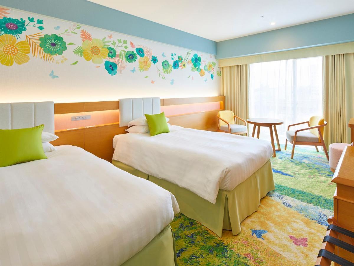 Grand Nikko Tokyo Bay Maihama Hotel Urajaszu Kültér fotó The photo shows a brightly decorated hotel room featuring two twin beds with white linens and light green accents. Above the beds is a colorful floral mural that adds a cheerful touch to the space. There is a small table and chairs by the window, whi