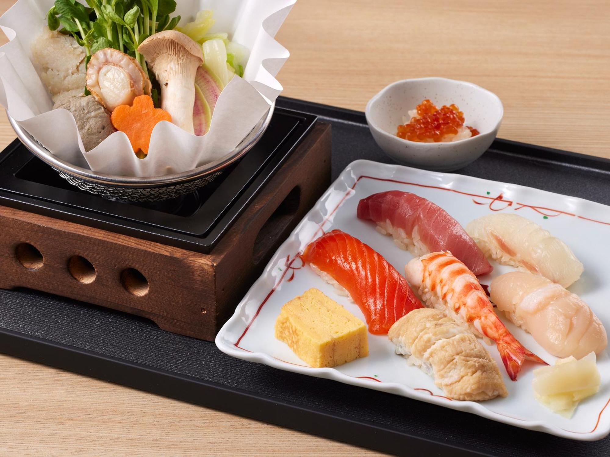 Grand Nikko Tokyo Bay Maihama Hotel Urajaszu Kültér fotó The photo features a Japanese meal presented on a wooden tray. On the left, there is a small pot with a clear broth containing vegetables, mushrooms, and possibly meat, indicated by green herbs and a piece shaped like a flower. On the right, there is